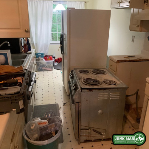 Appliance removal in Kennesaw GA featuring old refrigerator and electric stove pickup by junk Man Junk removal and hauling during a residential appliance clean out.