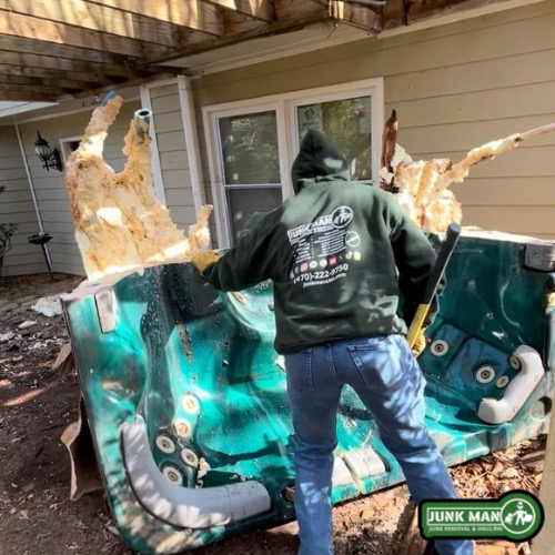 Junk Man crew loading hot tub debris onto trailer during professional hot tub removal service in Kennesaw GA